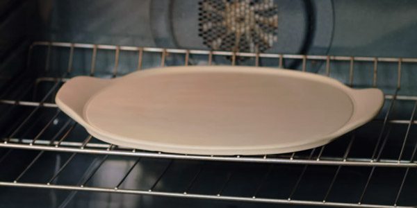 How do you use a Pampered Chef pizza stone for the first time